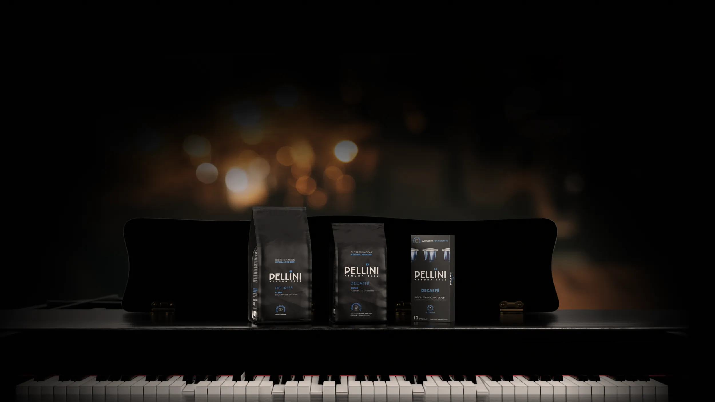 Miscela Decaffè Decaffè nei formati in grani, macinato moka e capsule, disposti su un pianoforte