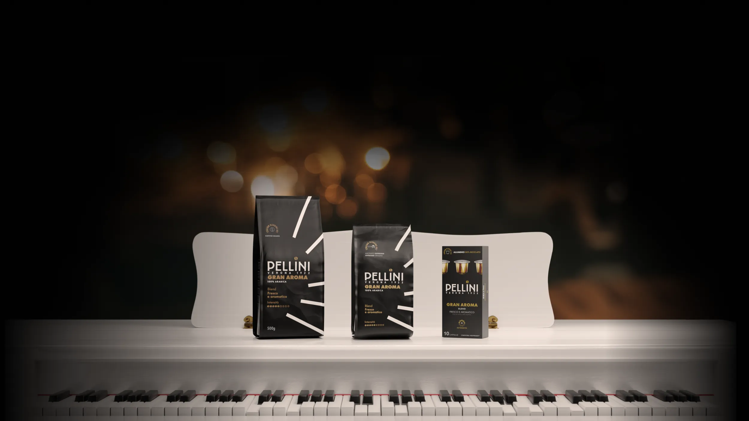 Confezioni di caffè Pellini miscela Gran Aroma nei formati in grani, macinato espresso e capsule, disposti su un pianoforte
