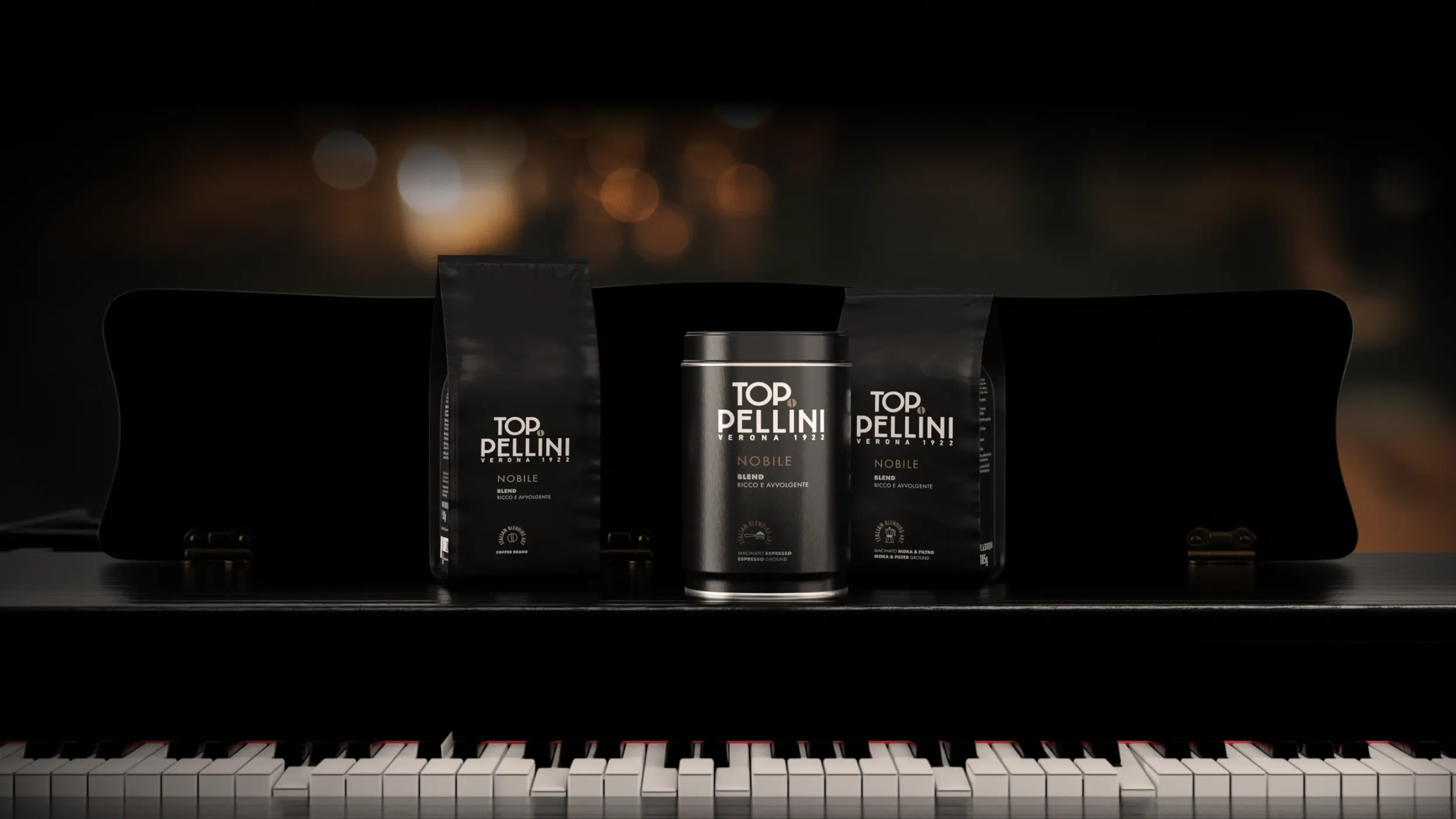 Confezioni di caffè Pellini miscela Top Nobile nei formati in grani, macinato moka ed espresso, disposti su un pianoforte