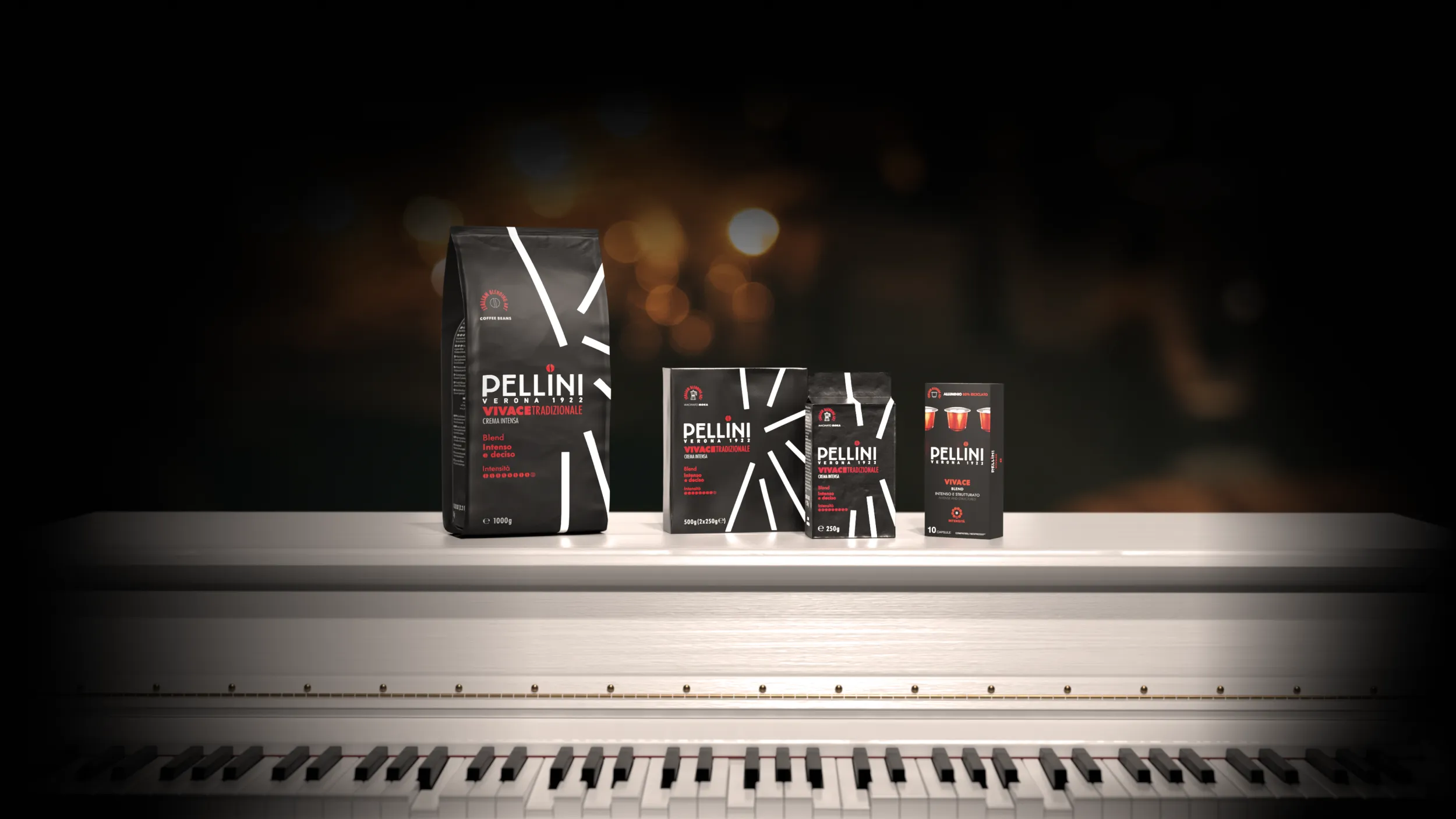 Confezioni di caffè Pellini miscela Vivace Tradizionale crema intensa nei formati in grani, macinato moka e capsule, disposti su un pianoforte