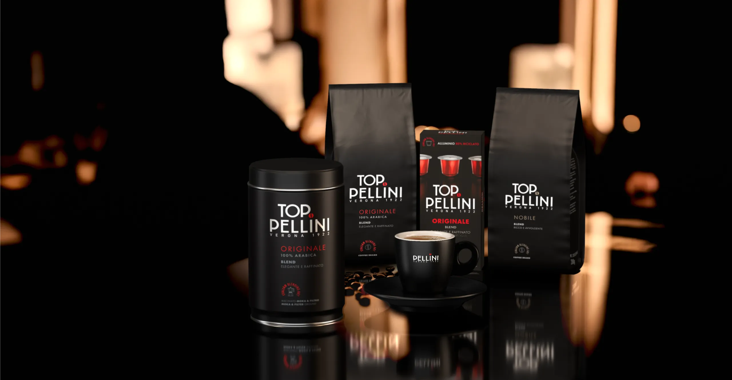 Lancio linea top Pellini Tavolo di un bar con tazzina di caffè Pellini e confezioni delle miscele Top originale e Top Nobile in grani, macinato e capsule